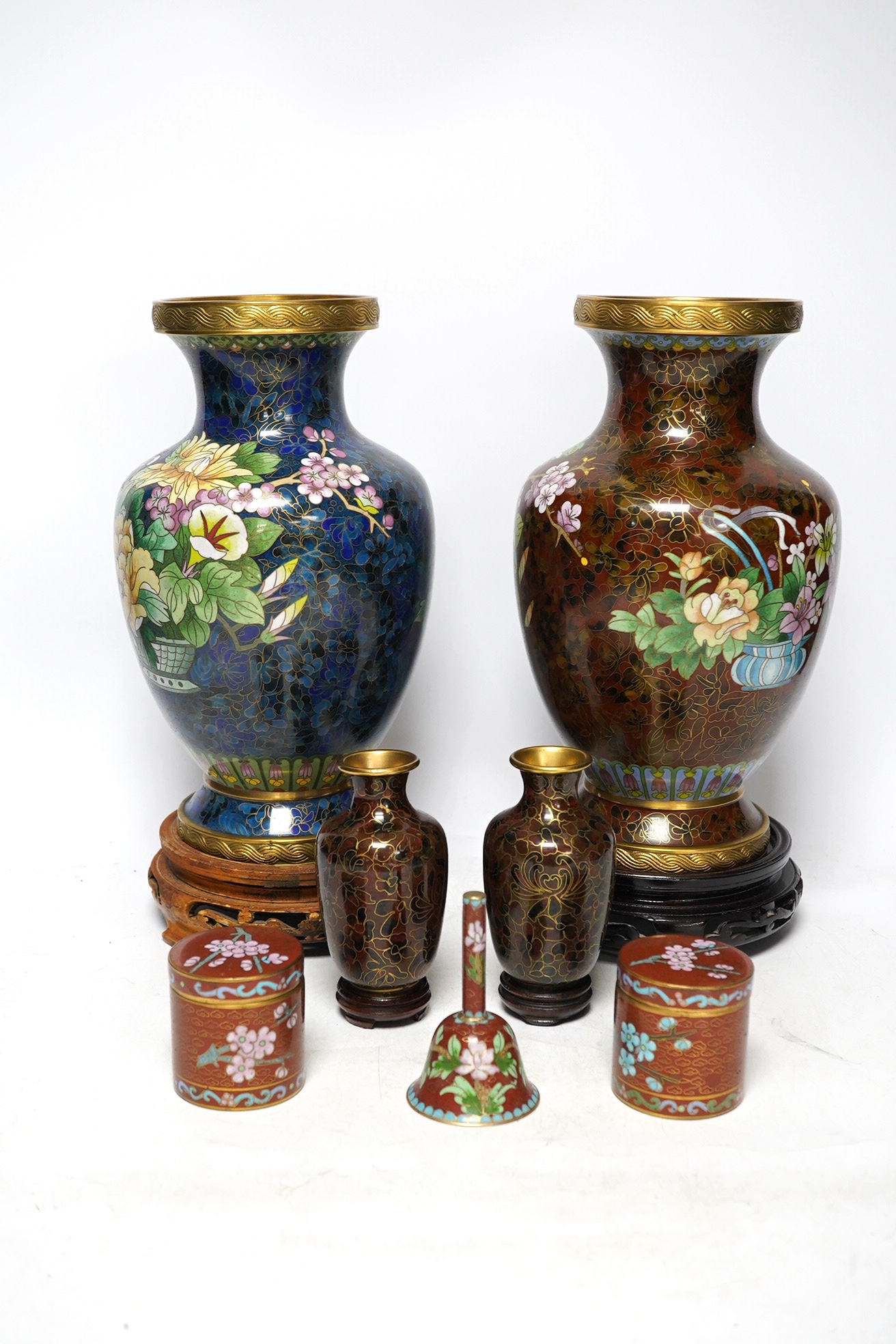 Two large Chinese cloisonné vases with hardwood stands, a smaller pair of vases, a pair of similar boxes and covers and a small table bell, tallest 31cm. Condition - fair to good